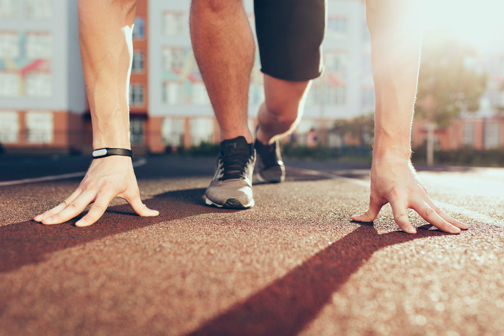 muscle-hands-sunlight-legs-in-sneakers-of-strong-guy-on-stadium-in-the-morning-he-has-preparation-on-start
